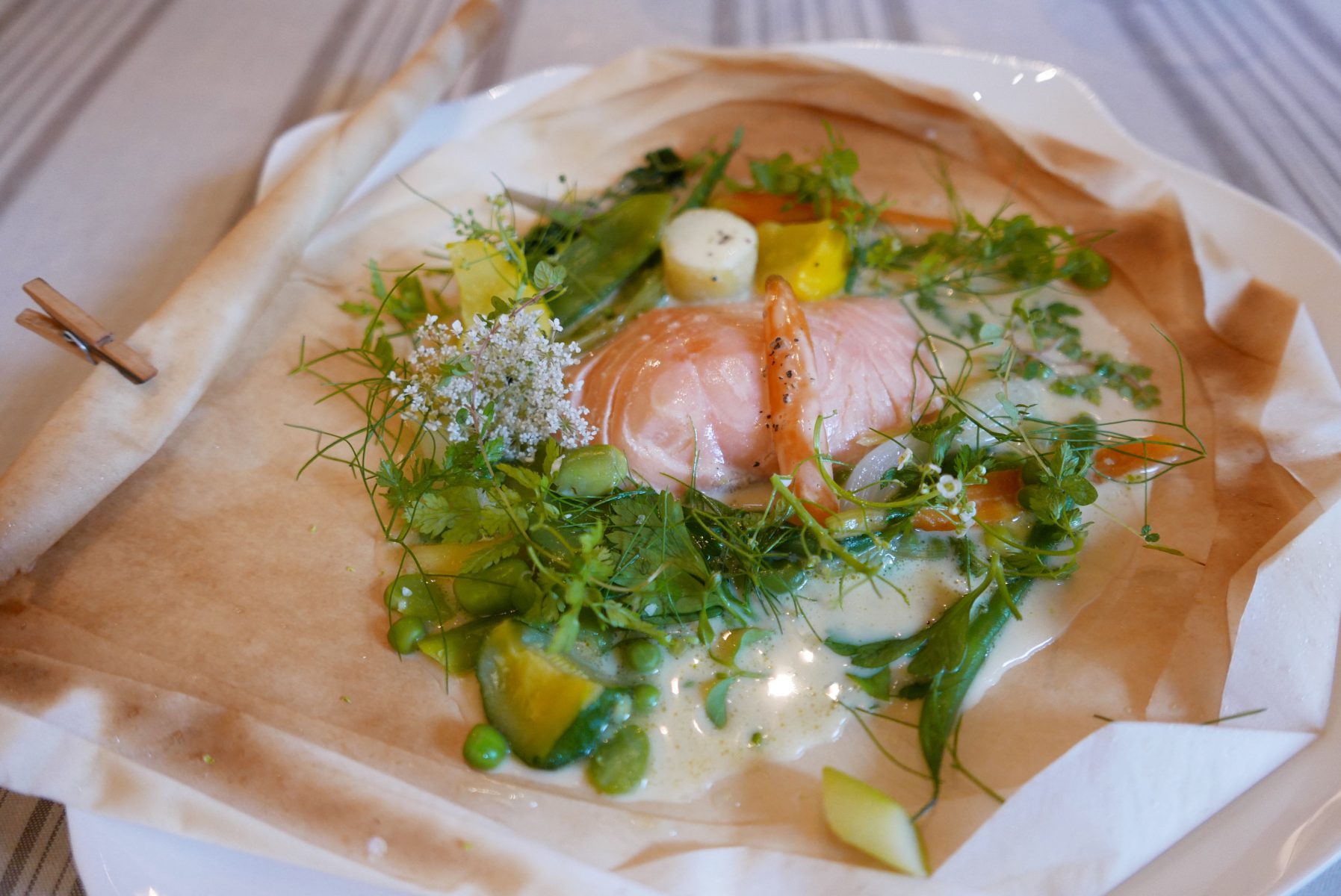 Salmon "en papillote" with vegetables from the garden and corn bouillon