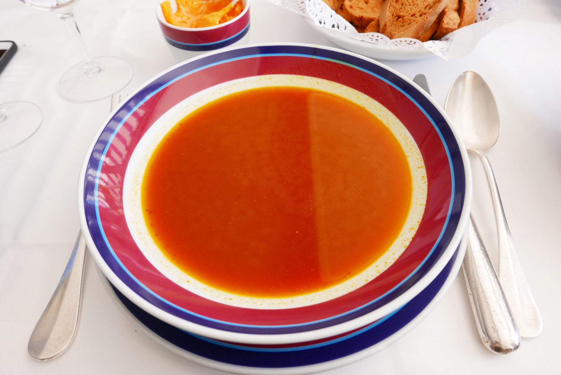 The soup is served with rouille sauce, potatoes and croûtons