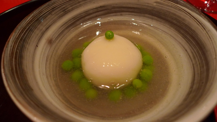 Potato purée ball with mushrooms inside, warm jelly and slightly heated al dente green peas