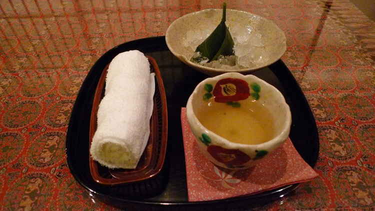 Towel, green tea with a cake filled with sweet bean paste