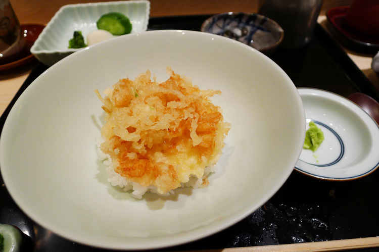 Ten- cha- kakiage on a bowl of rice. Kakiage is a mixture of bits of scallops and  honewort fried in batter. It's served with special Japanese tea.