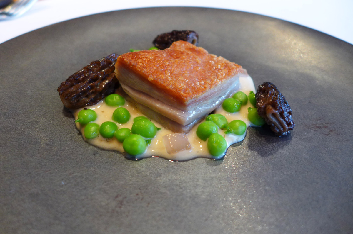 Slowly cooked pork with crispy skin, yellow wine sauce, smoked pancetta, peas