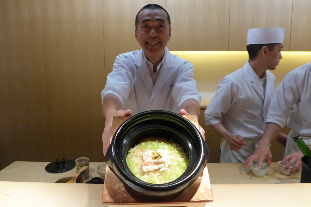 Ishikawa-san holding rice with hairy crab