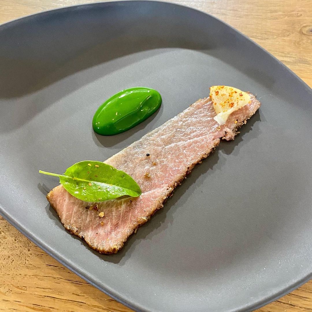 Smoked bluefin tuna belly pastrami, served with herbs and curry